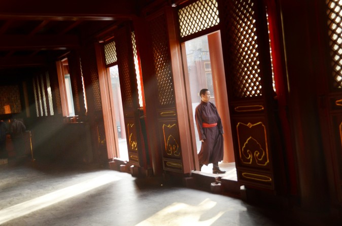 Un monje pasa junto a una puerta en el templo lama Yonghegong  en Beijing el 24 de octubre de 2012. (Wang Zhao / AFP / Getty Images)